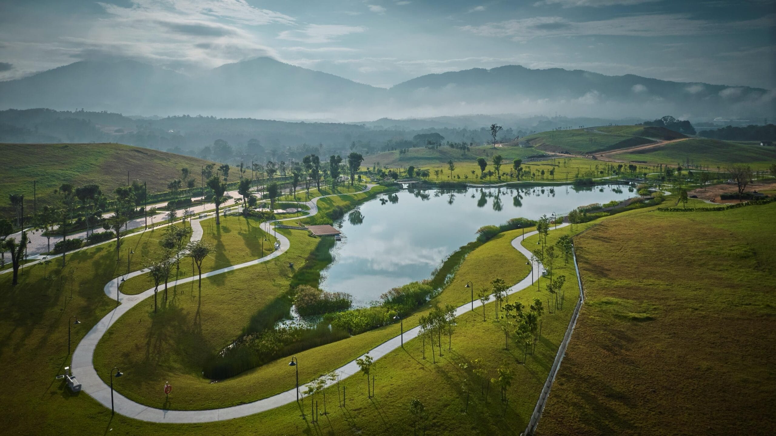 The lake, walking paths and green hills at Anyara Hills